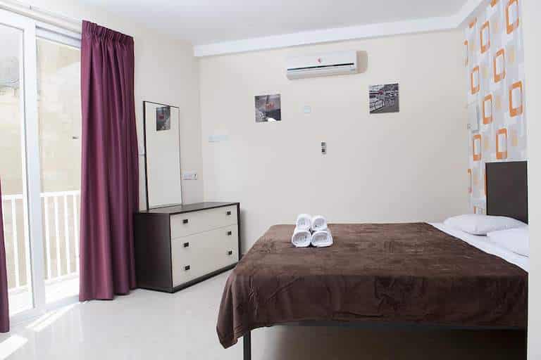 Slaapkamer met tweepersoonsbed en balkondeur in Tigne Residence